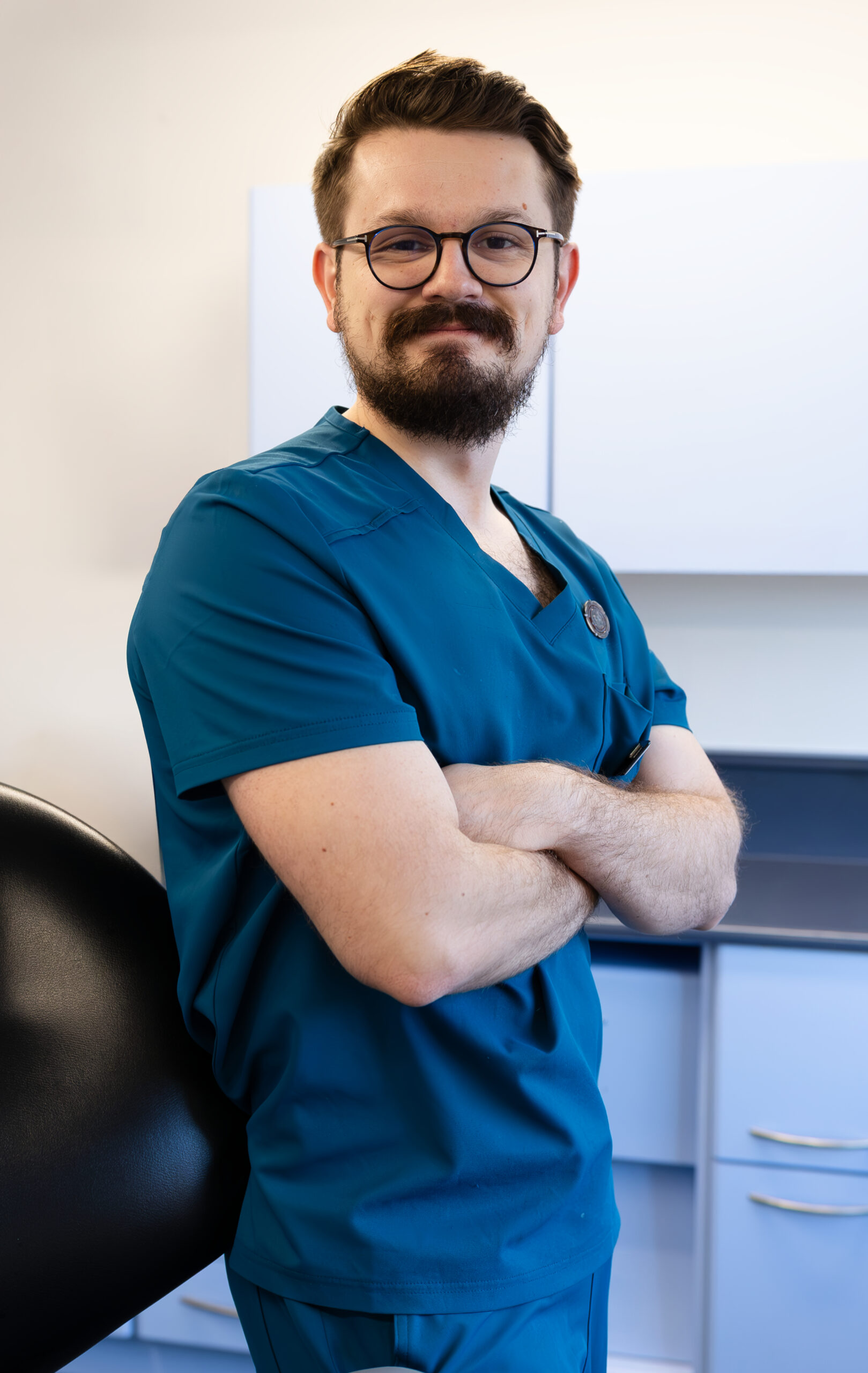 Oliver dentist with arms folded smiling