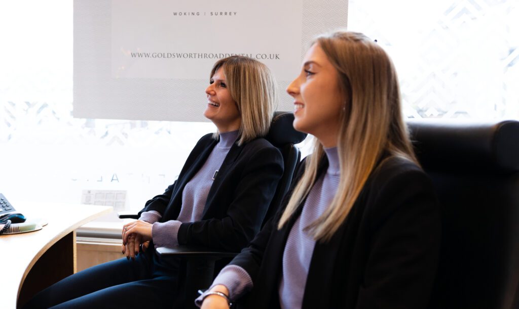 Two reception women with blonde hair smiling looking away from camera