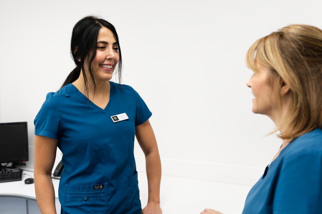 Two female dentists talking and smiling