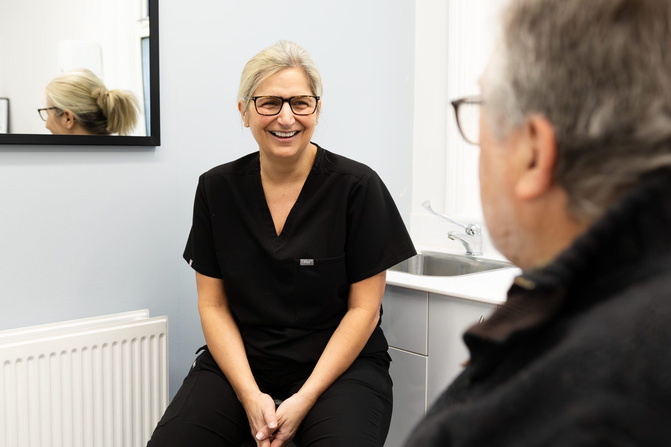 Female with blonde hair smiling at a man with glasses