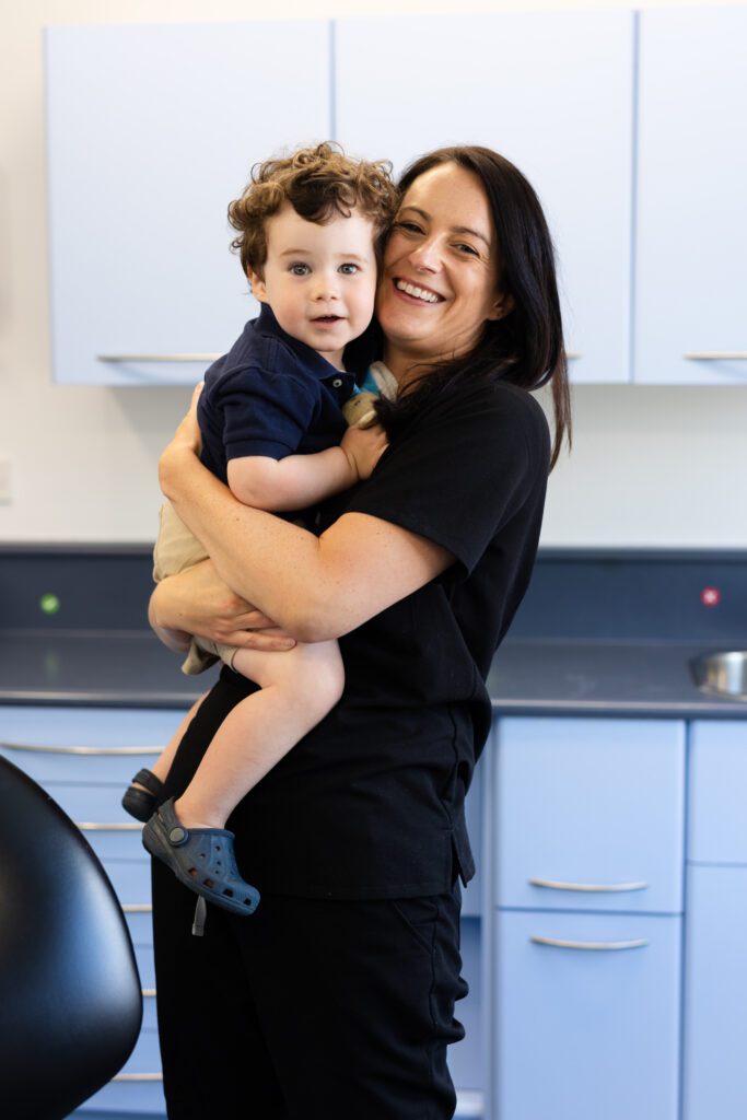 female dentist holding a child smiling