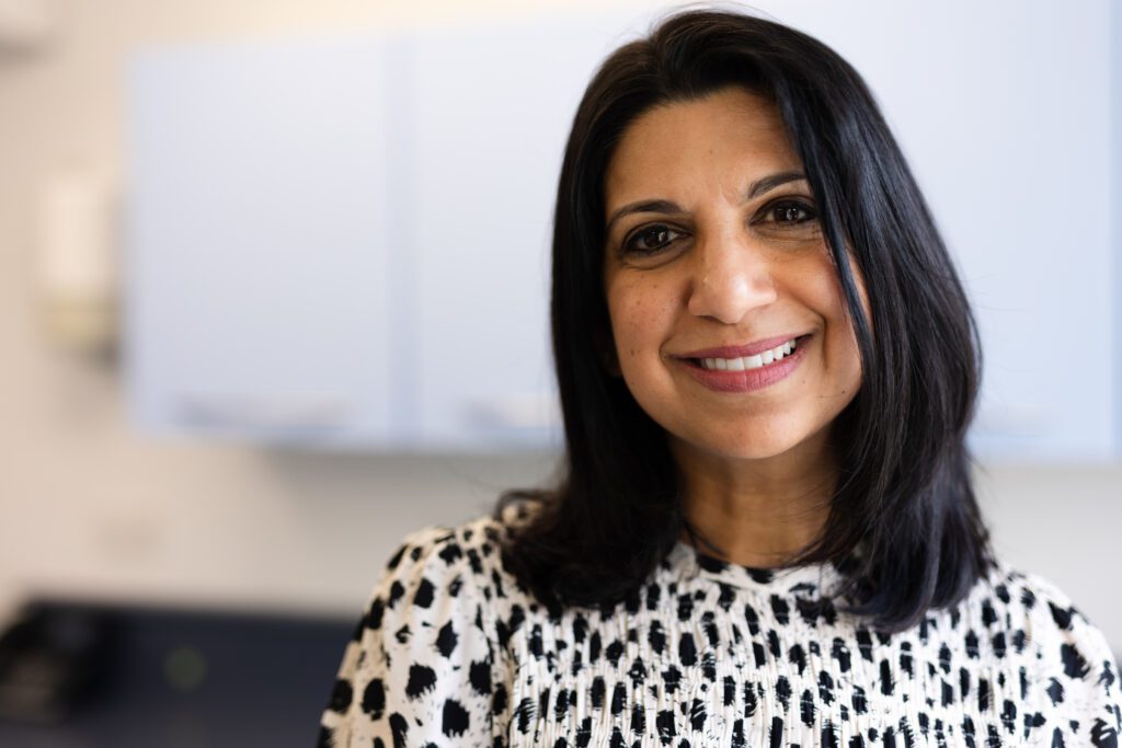 female smiling at camera with brown eyes and shoulder length dark hair