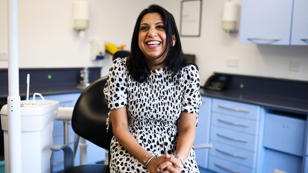 Female patient sat in the dentist chair looking happy